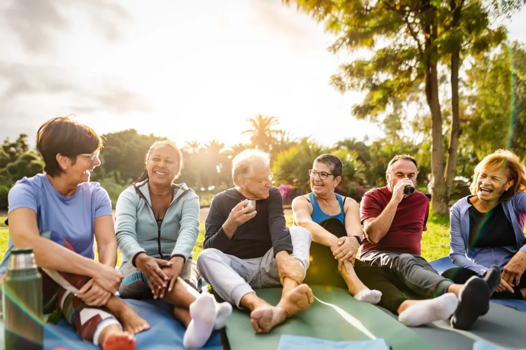 six senior friends enjoy the sunshine outside of Monarch Landing, an Independent living community in Naperville, IL