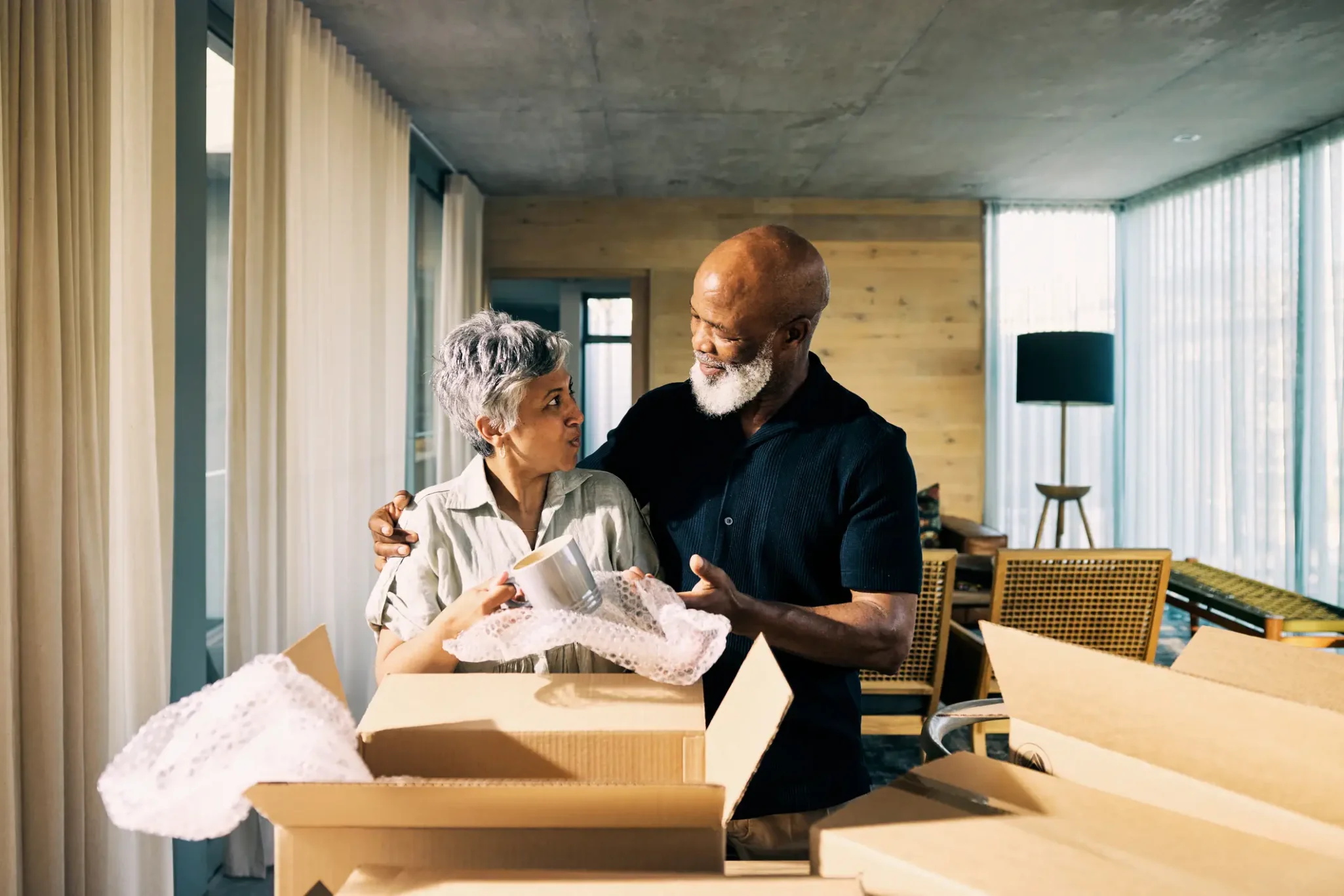 Senior couple unpacking moving boxes