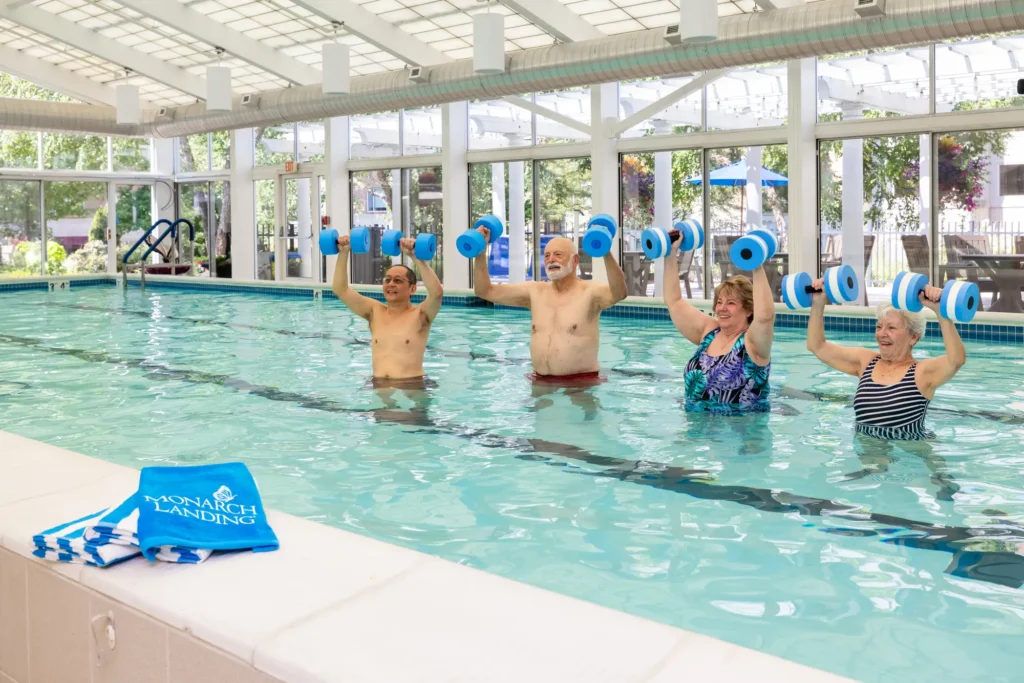 A group of seniors doing pool exercises at Monarch Landing showing a retirement home where neighbors become family in Naperville, IL.