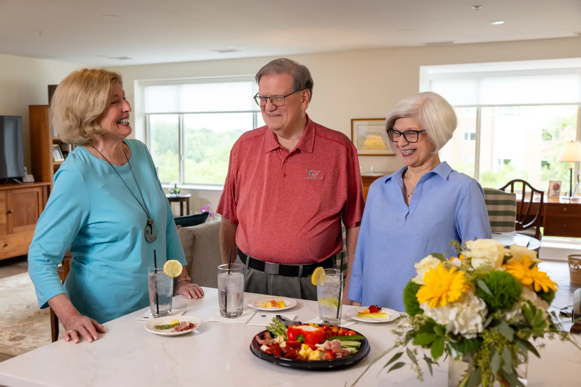 senior neighbors chatting in kitchen at Monarch Landing, showing a retirement community where neighbors become friends.