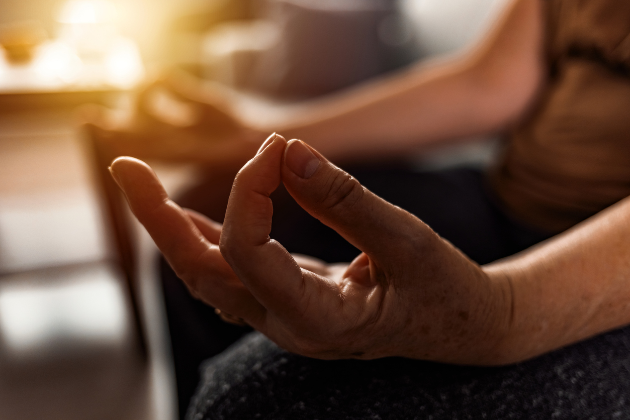 Serene elderly woman meditating at home