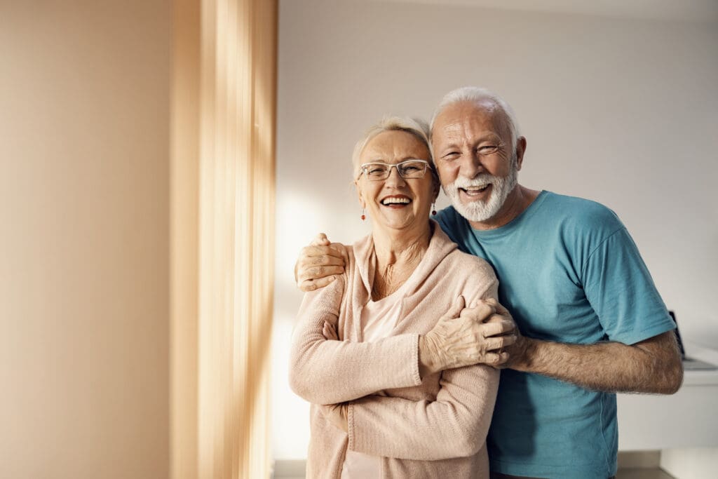 Happy senior couple in house after learning about retirement planning tips.