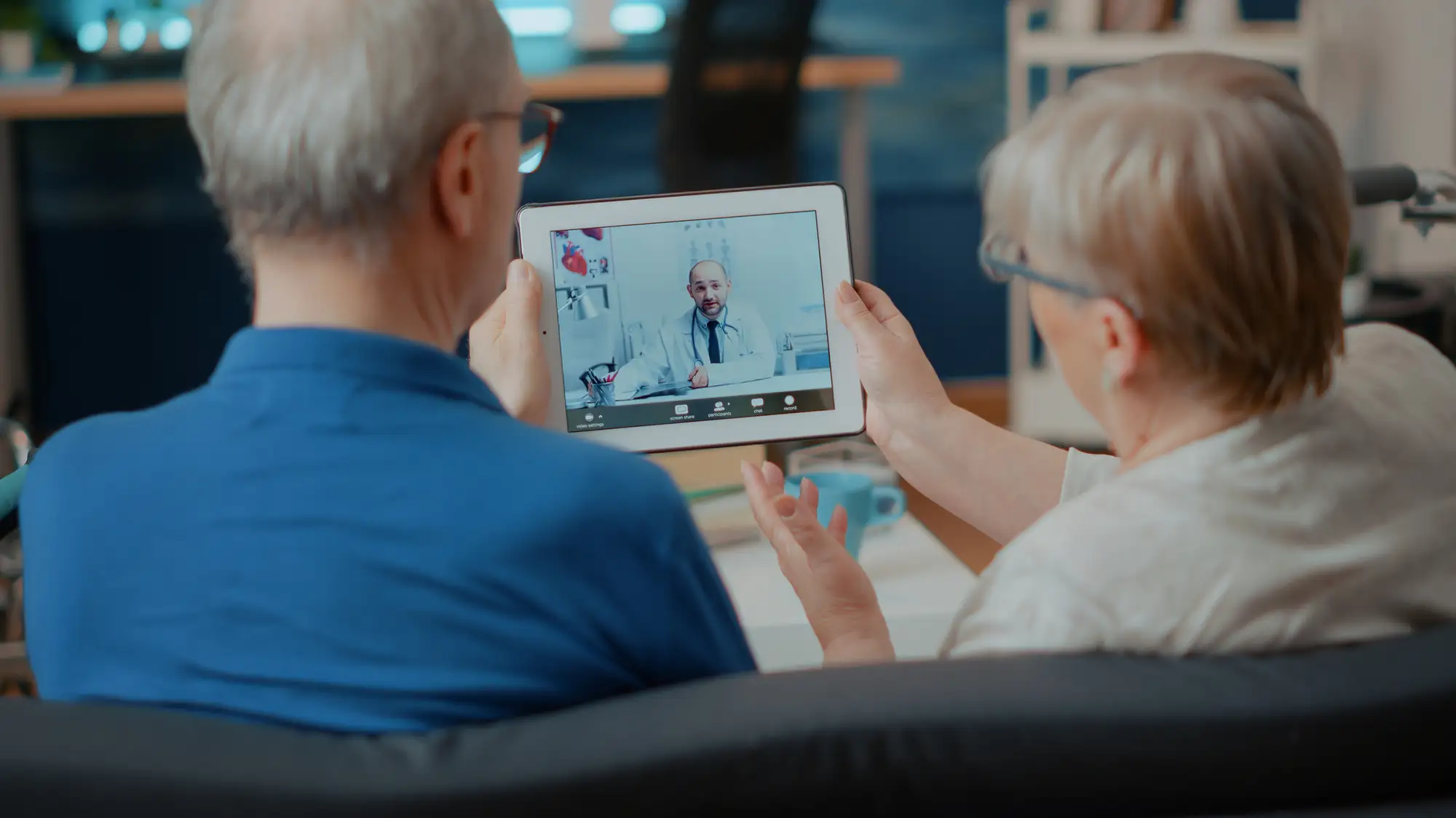 Elderly couple talking to doctor on tablet at The Springs in Monarch Landing, as a part of their virtual urgent care program.
