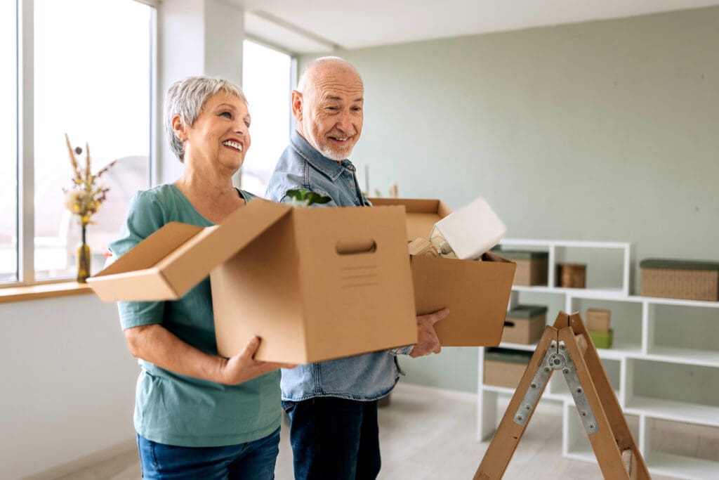 Seniors holding moving boxes