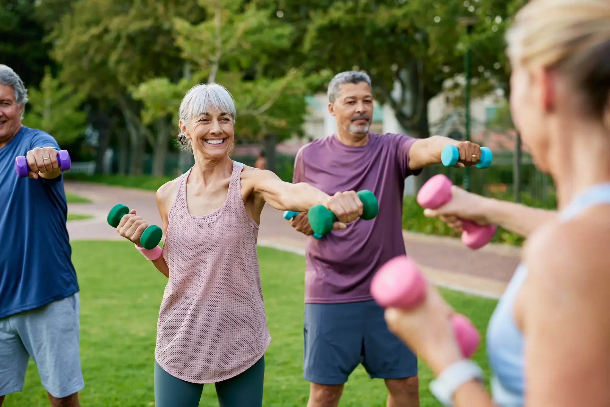 Seniors exercising with hand weights outdoors
